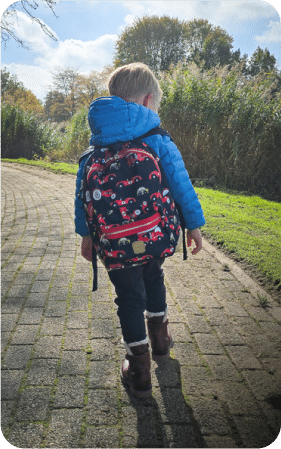 L'enfant porte le même sac à dos à l'extérieur